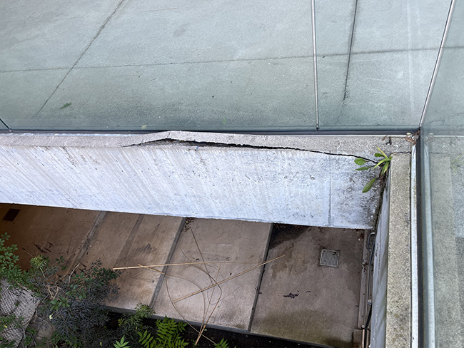 Spalling of concrete at edge of gallery fascia.