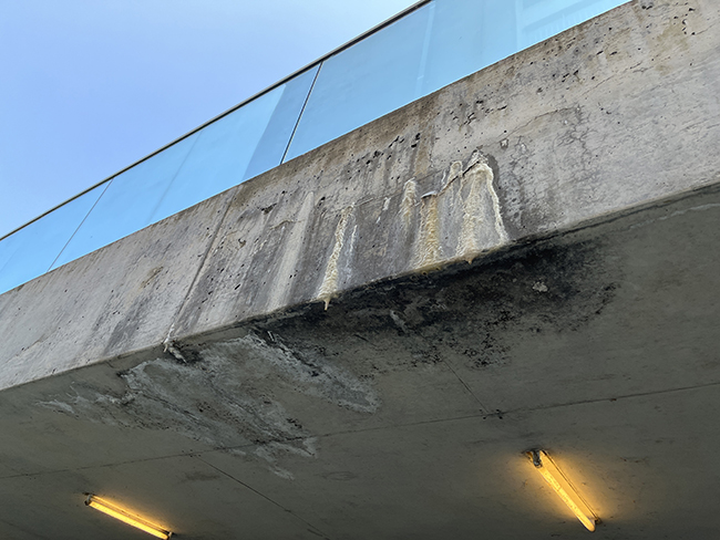 Efflorescence at fascia and soffit of cantilevered concrete slab at ramp.
