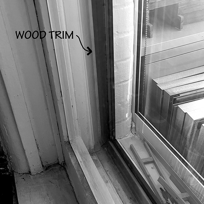 Window showing wood trim near fire-rated glazing.