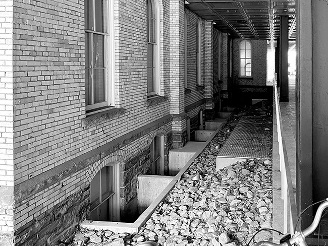 View of arcade showing basement and first-floor windows in Sibley Hall fire barrier wall.
