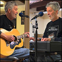 Jonathan Ochshorn playing guitar and keyboards at performance in Cortland